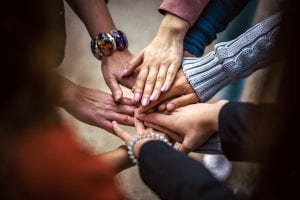 several hands touching in show of team spirit